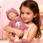 Reborn doll girl holding a Shrek-themed silicone toy doll, realistic baby doll for collectors and ch.