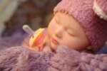 Realistic silicone reborn baby girl doll with pacifier, detailed features.