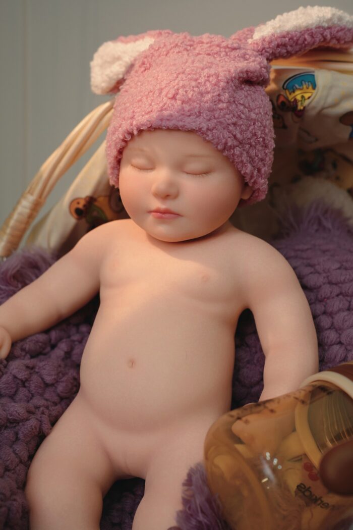Silicone Reborn Baby Doll with pink bunny hat, lifelike features, and soft skin. Perfect for collect.