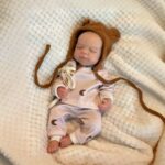 Reborn doll dressed as a baby with a cute bear hat, perfect for collectors and gift-giving.