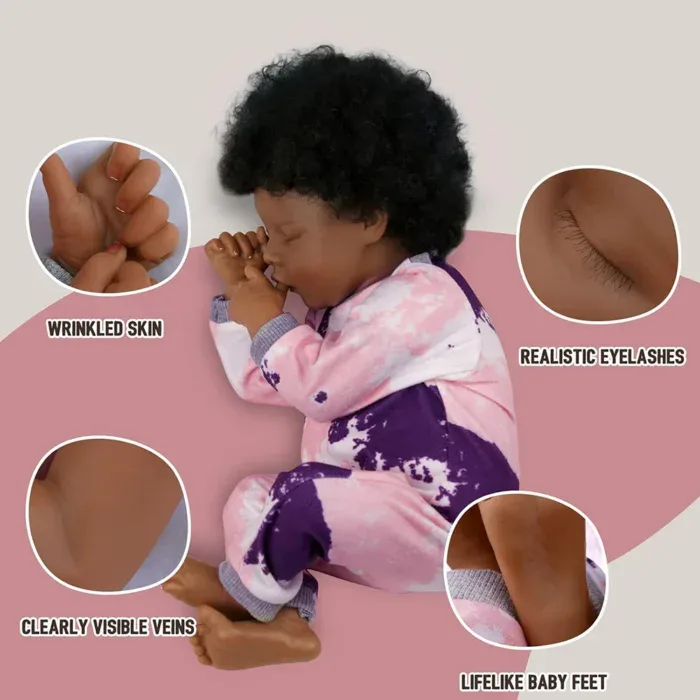 Realistična tamnoputa lutka beba s ukorijenjenom kosom, u pozi za spavanje i detaljnim crtama lica.