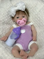 Atdzimušas meitenes lelle ar sakņotiem matiem, atvērtu muti un reālistiskām iezīmēm, ideāli piemērota kolekcionāriem un bērniem.