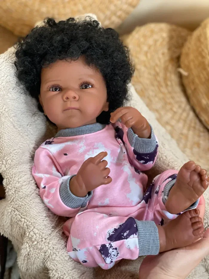 Baby doll with dark skin, realistic features, and curly hair, perfect for children’s birthday gifts.
