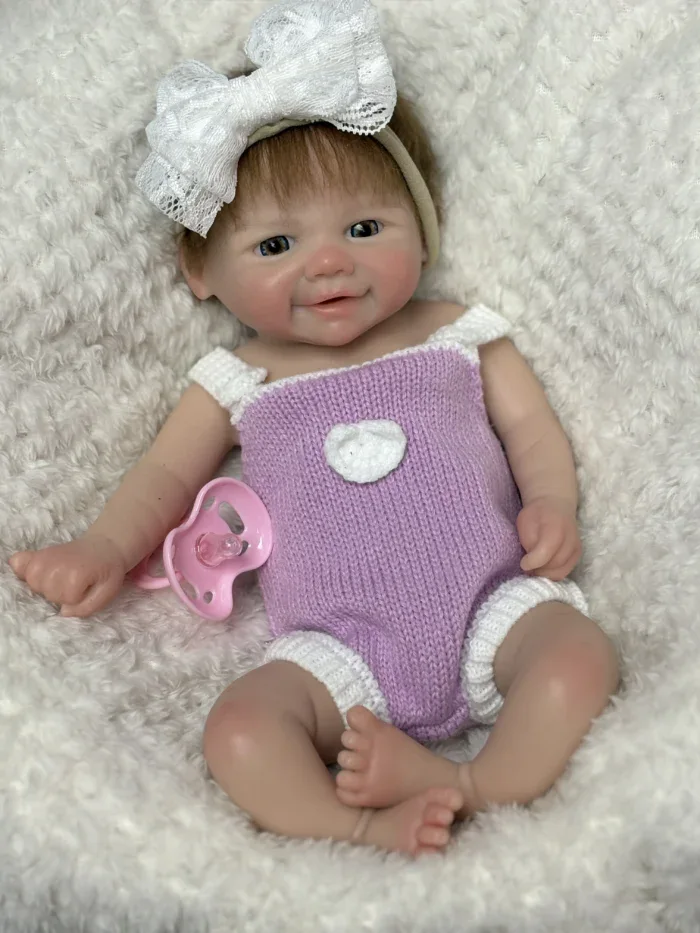 Atdzimusi lelle ar atvērtu muti, sakņotiem matiem un reālistiskām iezīmēm, ideāli piemērota kolekcionāriem un bērniem.