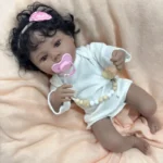 Znovuzrozená panenka s tmavou pletí, černými kudrnatými vlasy a realistickými rysy, ideální pro sběratele.