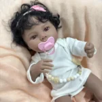 Znovuzrozená panenka s tmavou pletí, kudrnatými černými vlasy a realistickými rysy, ideální pro sběratele.