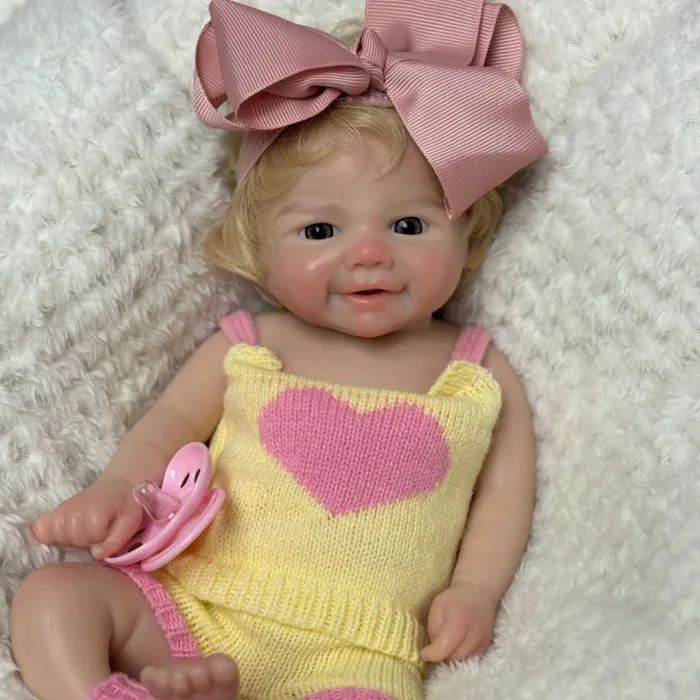 Atdzimusi lelle ar reālistisku silikona ādu, rozā bantīti un sakņotiem matiem, ideāli piemērota kolekcionāriem un bērniem.