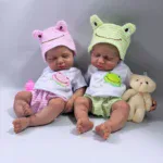 Rozkošné silikonové reborn panenky s kloboučky s motivem žáby, měkké a omyvatelné, ideální pro sběratele.