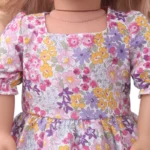 Šaty pro reborn panenku s růžovým, fialovým a žlutým květinovým potiskem, ideální pro panenky a malé holčičky o velikosti 45 cm.