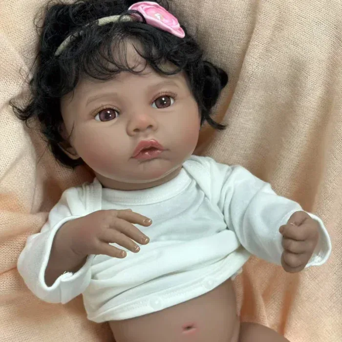 Znovuzrozená panenka s tmavou pletí, kudrnatými černými vlasy a realistickými rysy, ideální pro sběratele.