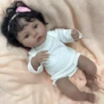 Reborn panenka Meadow s tmavou pletí, černými kudrnatými vlasy a realistickým vinylovým tělem, ideální do sbírky.