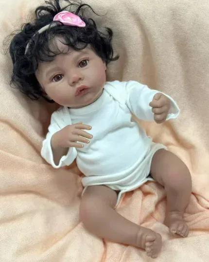 Znovuzrozená panenka s tmavou pletí, kudrnatými černými vlasy a realistickým vinylovým tělem, ideální pro sběratele.