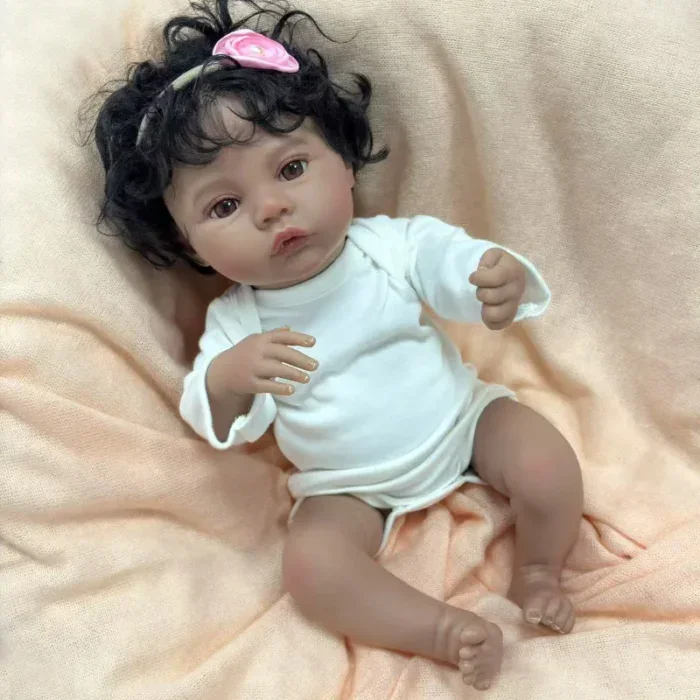 Znovuzrozená panenka s tmavou pletí, kudrnatými černými vlasy a realistickými rysy, ideální pro sběratele.