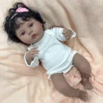 Realistická 45cm silikonová reborn panenka s tmavou pletí, kudrnatými černými vlasy a realistickými rysy.