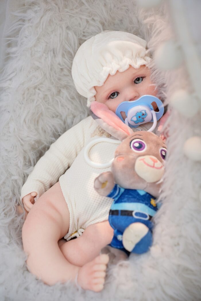Silikonová panenka Reborn s realistickými rysy, modrýma očima a měkkým oblečením. Ideální pro sběratele.