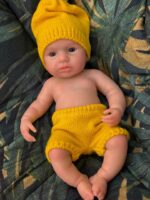 Poupée reborn en silicone de haute qualité ressemblant à un vrai bébé, vêtue d'un chapeau jaune et d'un short pour la vie.