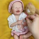 Poupée reborn réaliste en silicone, pleurant, pour collectionneurs et enfants. Fabriquée à la main avec des détails soignés.