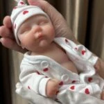 Realistična Reborn lutka od 20 cm s oslikanim detaljima i mekom odjećom.