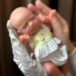 Păpușă reborn adorabilă, fetiță cheală, de 20 cm, perfectă pentru colecționari și copii, realizată cu materiale realiste.