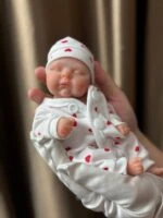 Realistična reborn lutka od 20 cm s 3D oslikanim crtama lica, idealna za kolekcionare i djecu, izložena.