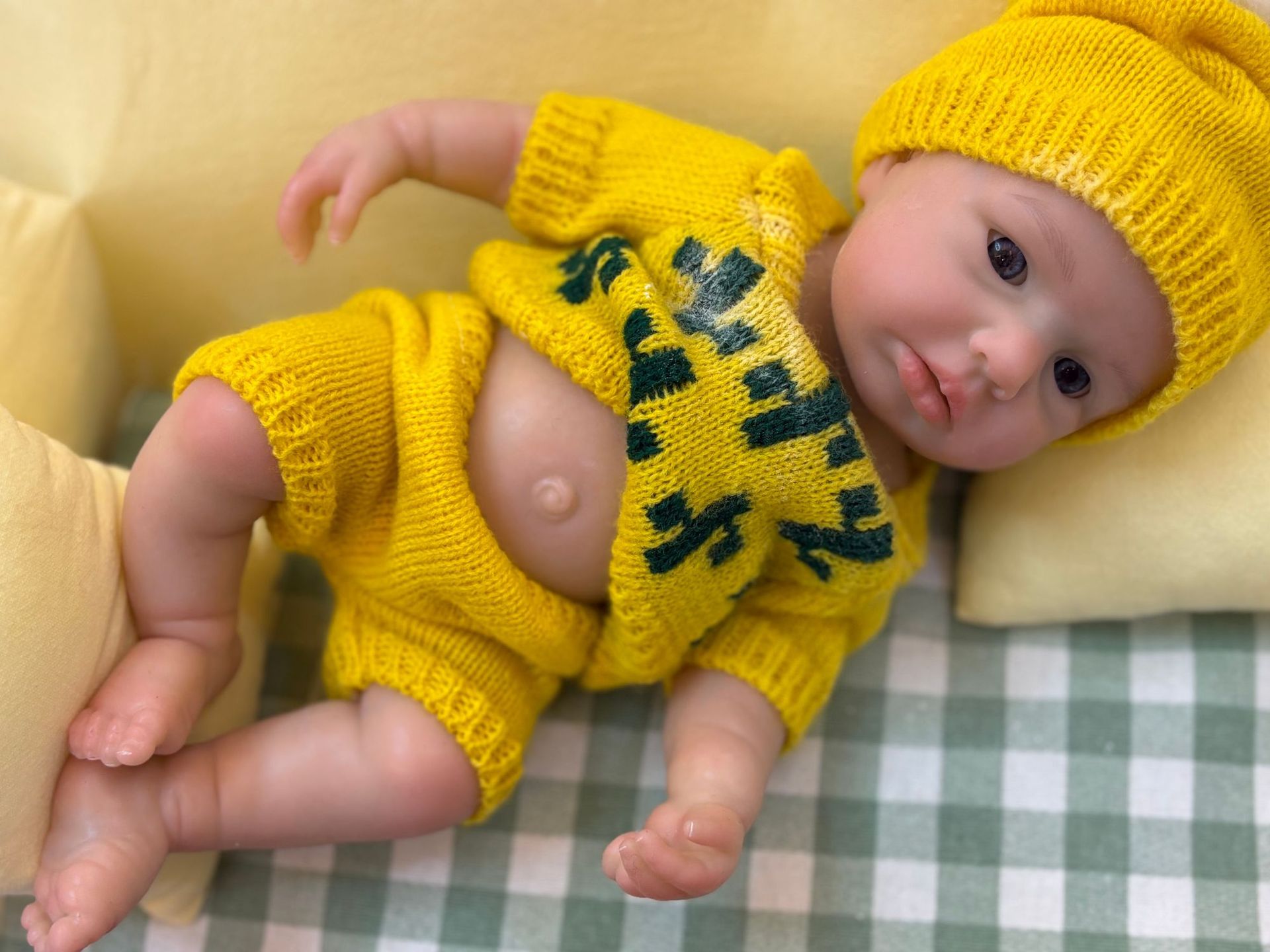 Poupée reborn portable en silicone de 33 cm, jouet 22 Poupée reborn réaliste en silicone, vêtue de vêtements et d'un chapeau jaunes, aux traits réalistes.