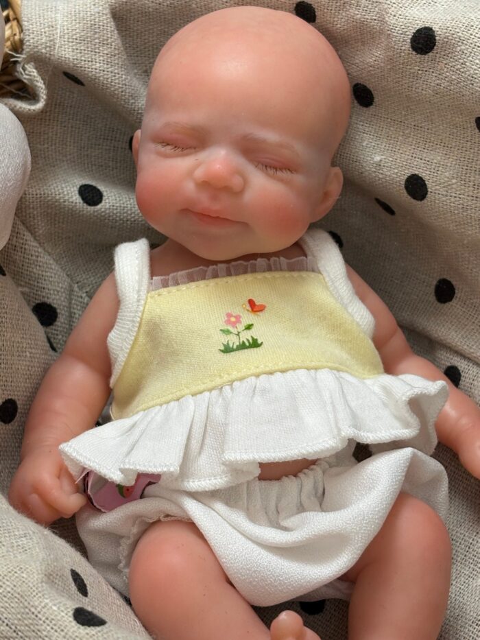 Păpușă reborn adorabilă de 20 cm, cu chelie, trăsături realiste și piele moale. Perfectă pentru colecționare.