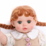 Reborn babypop met realistische groene ogen, rood haar en gedetailleerde kleding, perfect voor verzamelaars.