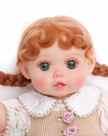Bambola reborn con occhi verdi realistici, capelli rossi e abiti dettagliati, perfetta per i collezionisti.