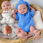 Realistische Reborn-Babypuppe mit offenen Augen, bekleidet mit einem blauen Strickoutfit, detaillierte Baby-Gesichtszüge.
