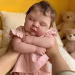 Realistic baby reborn doll sleeping with teddy bears, soft and lifelike.