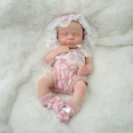 Realistische, mikro-frühgeborene Silikon-Reborn-Puppe mit rosa Outfit und Häubchen.