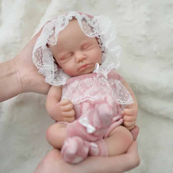 Adorable poupée reborn en silicone de 30 cm avec bonnet en dentelle et tenue rose.