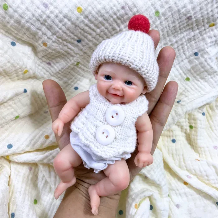 Adorável bonequinha de silicone com gorro e suéter de tricô para brincadeiras realistas.