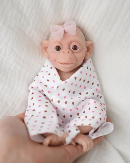 Adorable 7-inch silicone baby doll with wide eyes and pink bow.