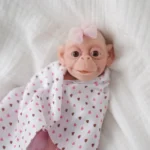 Adorable 7-inch silicone reborn baby girl doll with wide eyes and pink bow.