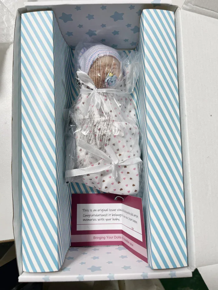Adorable 7-inch silicone reborn baby girl doll in box with accessories.