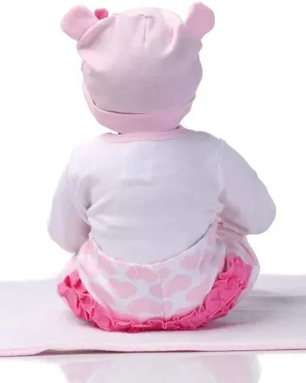 Lebensechte Babypuppe in rosa Outfit mit Bärenmütze, Ansicht von hinten.