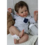 Cute toddler boy smiling with toy bear and water bottle.