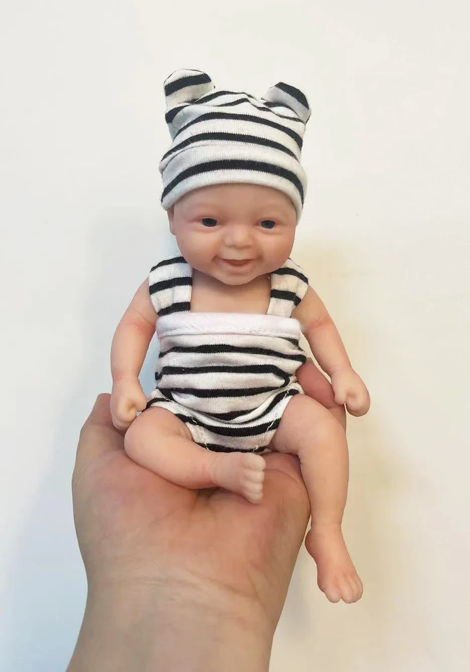 Мини кукла Reborn Baby в раиран тоалет Очарователна миниатюрна кукла преродено бебе с раирана шапка и облекло.