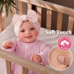Yndig smilende genfødt babypigedukke med blød hud og lyserødt outfit.