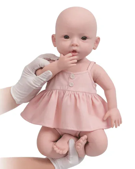Poupée bébé réaliste en silicone avec robe rose, traits réalistes et finitions soignées.