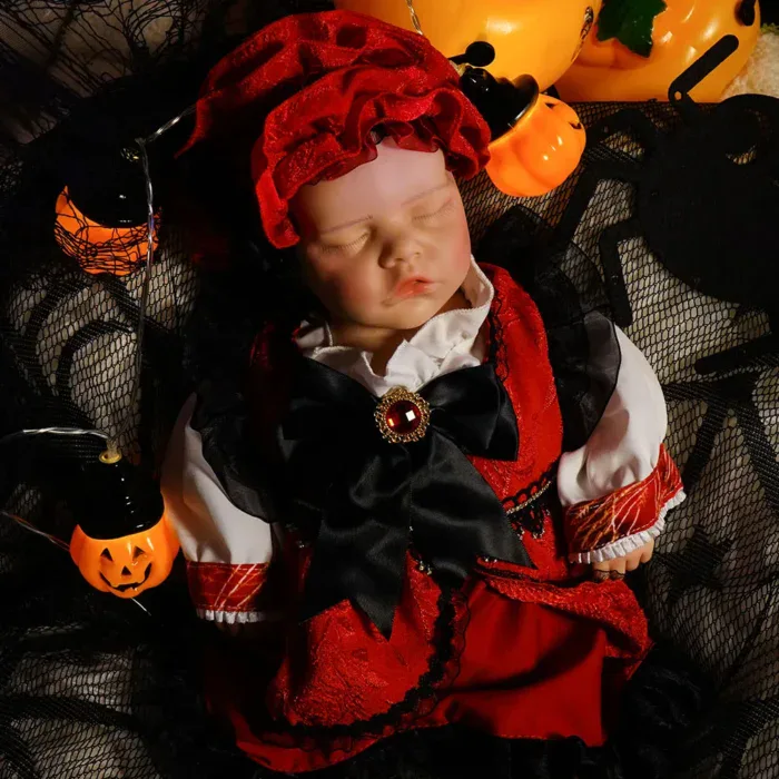 Poupée bébé fille endormie en costume d'Halloween avec des citrouilles et des lumières.