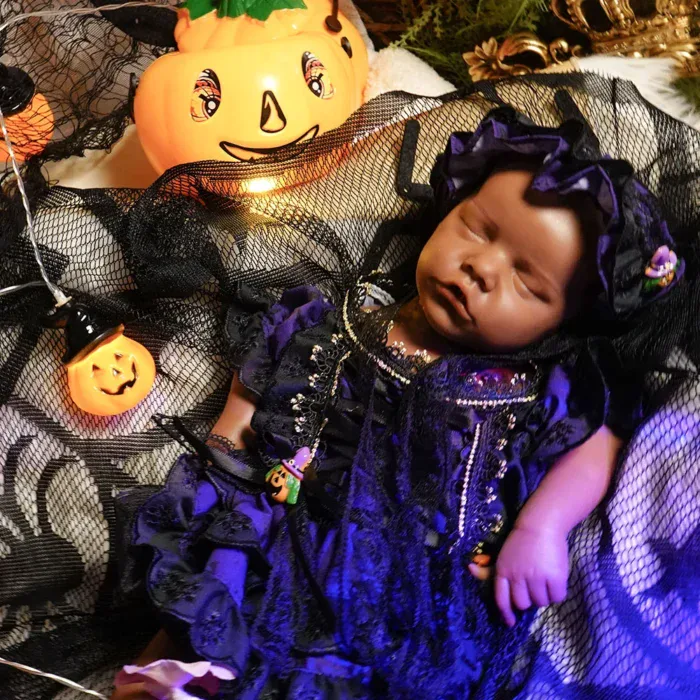 Poupée bébé réaliste pour Halloween, à la peau foncée et à la robe violette.