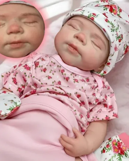 Realistic sleeping baby girl doll with floral outfit and hat.