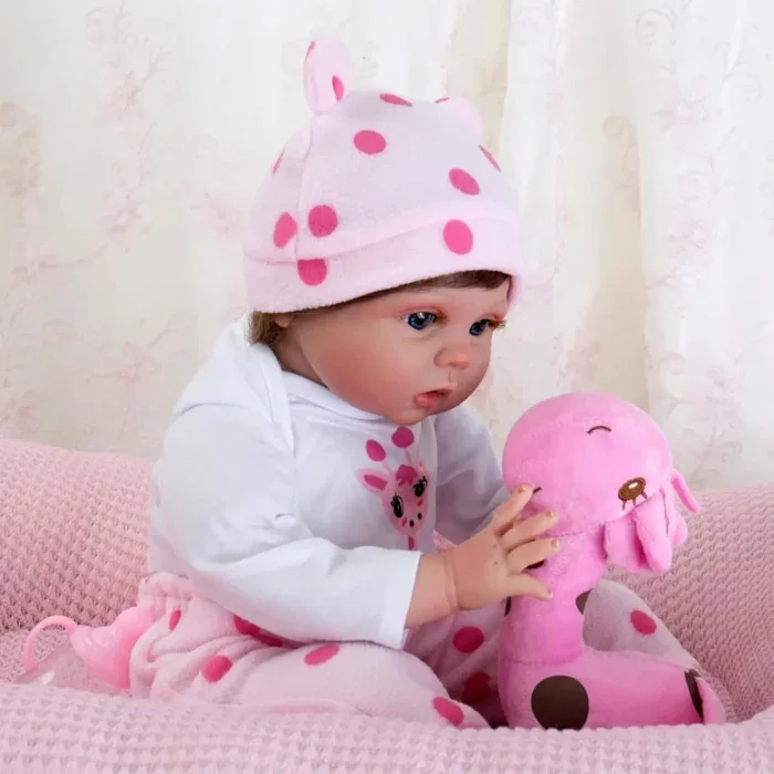 Niedliches Babymädchen mit rosa gepunktetem Hut spielt mit einem rosa Giraffen-Plüschtier.