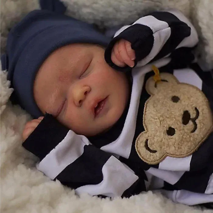 Entzückende schlafende Babypuppe (Junge) mit marineblauem Hut und gestreiftem Outfit.