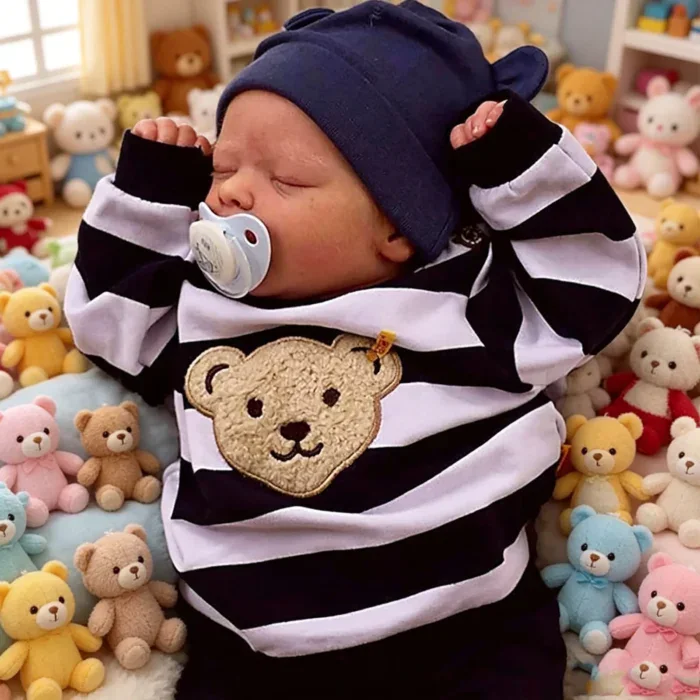 Realistische, schlafende Babypuppe mit Schnuller, die ein gestreiftes Hemd und eine marineblaue Mütze trägt.