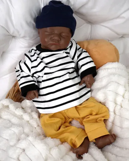 Bambola reborn realistica di un bambino nero con maglietta a righe e pantaloni gialli.
