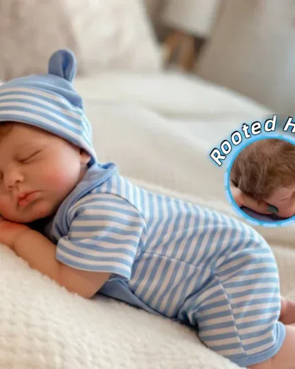 Realistic sleeping silicone reborn baby doll with rooted hair in blue outfit.