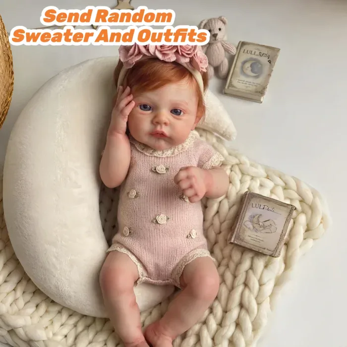 Adorable red-haired reborn baby girl doll with pink outfit and accessories.